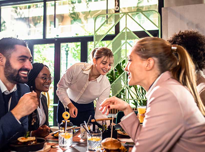 Smiling Waitress Serving Meal To Group Of Business 2023 11 27 05 00 35 Utc